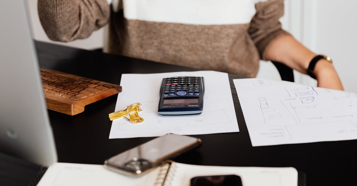 a business desk setup with a calculator papers and a keyboard reflecting a work environment