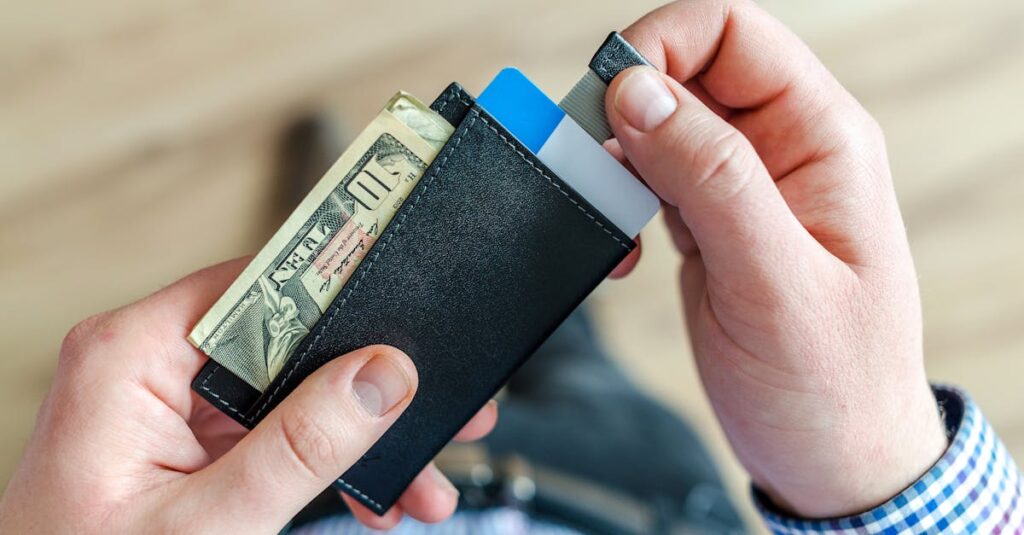 close up of a man s hands holding a wallet with cash and credit cards indicating financial manageme