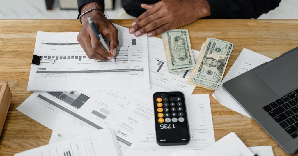 man working on financial reports with calculator money and laptop on a desk