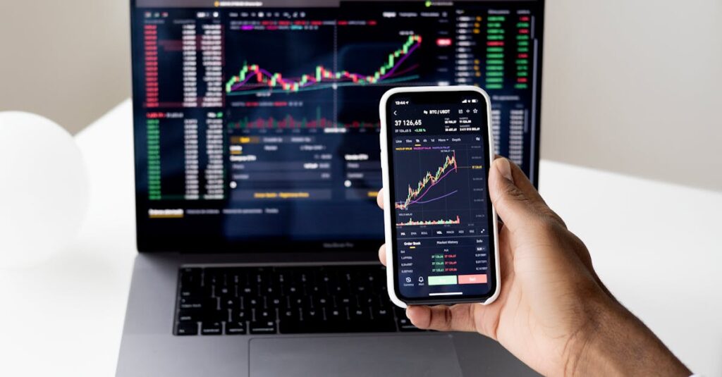 person checking stock market graphs on laptop and smartphone focusing on financial data 1